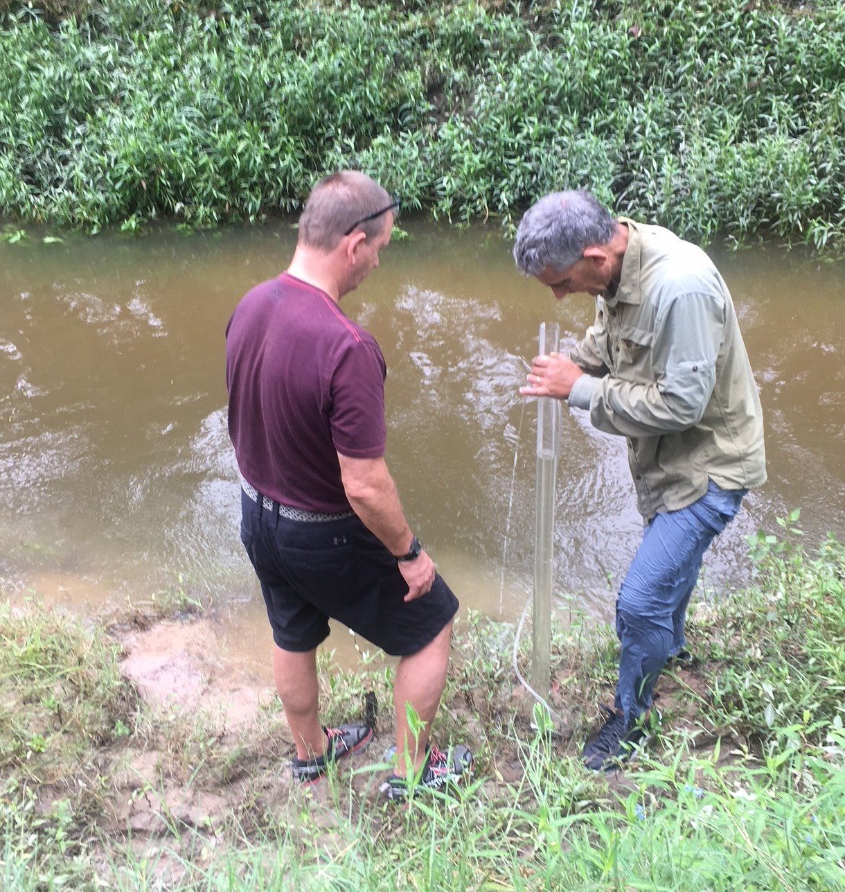 Volunteers monitoring water beside a stream